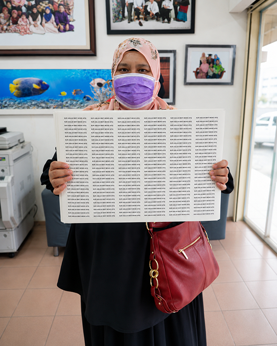 Customer holding a completed A3 sheet of personalised school name stickers